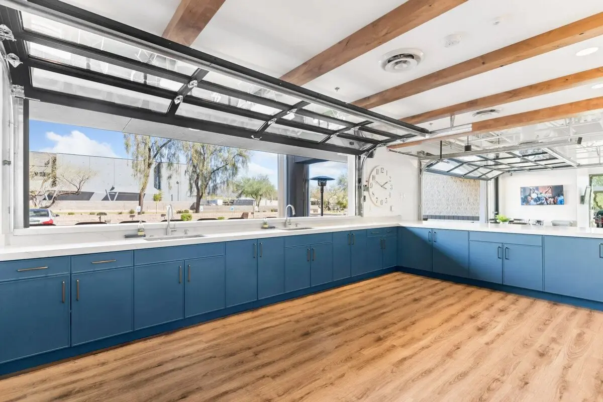 Hospitality kitchen with blue cabinetry and pass-through doors