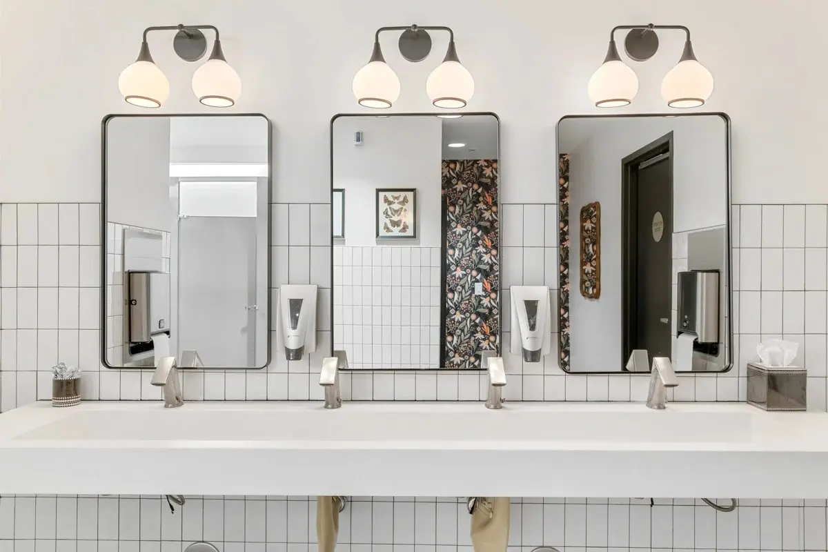 Renovated restroom with floral wallpaper and custom vanity